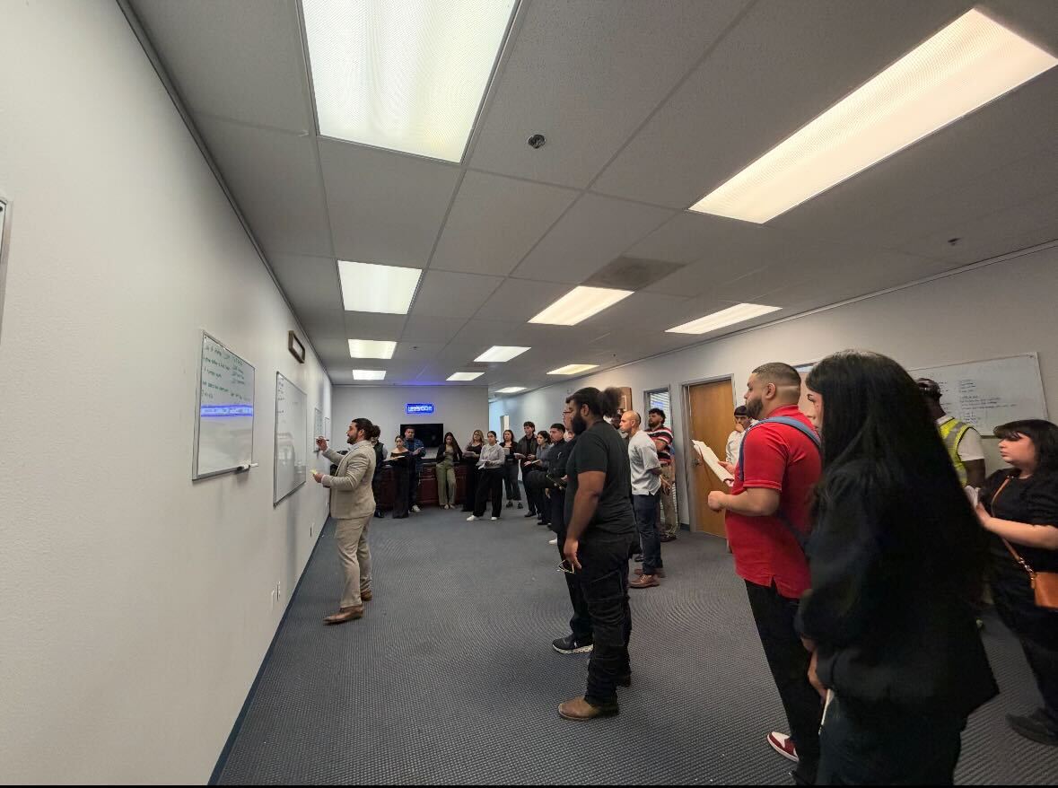 Sales team engaged in daily training and coaching session